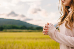 A young woman shows the symbol of prayer