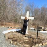 Woman next to cross