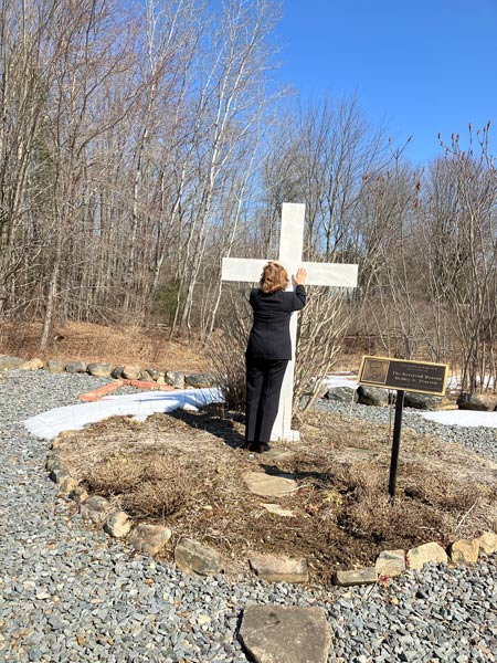 Woman next to cross